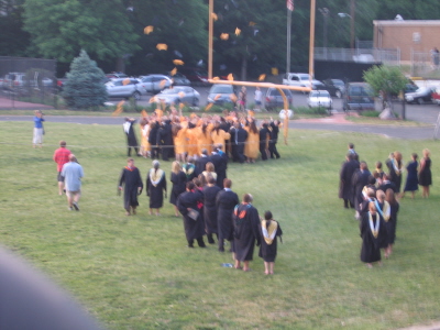 The Graduates Toss Their Caps Into The Air